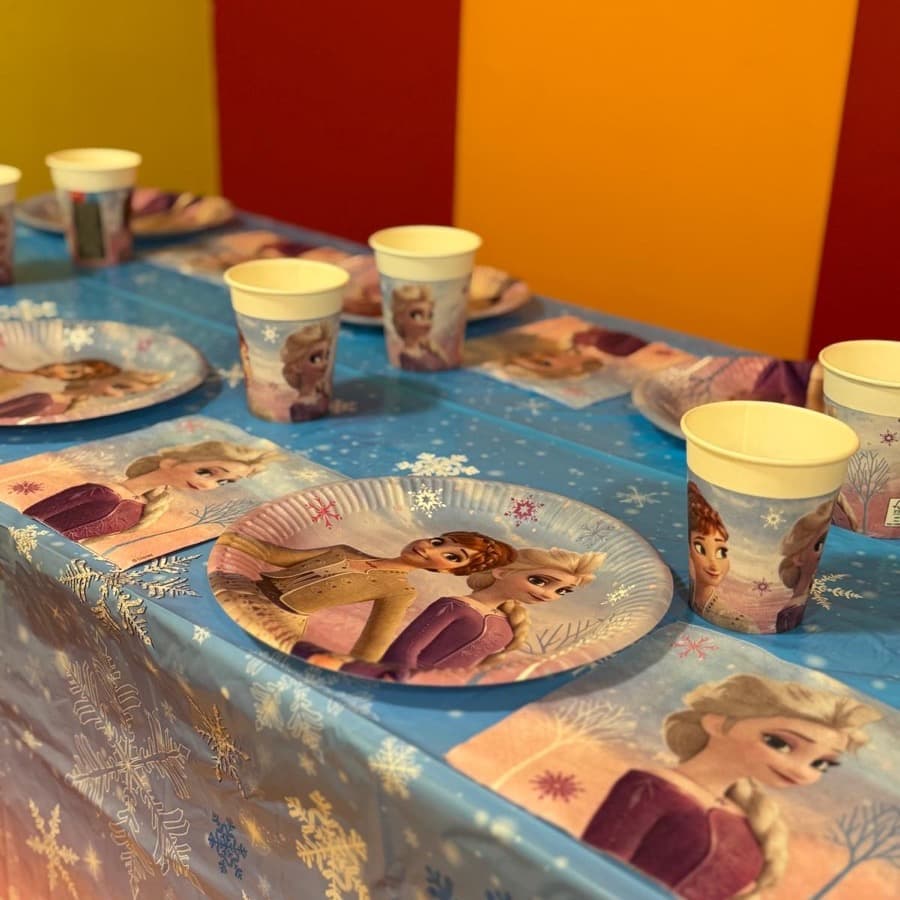 A party table set with icy blue snowflake plates, cups and napkins